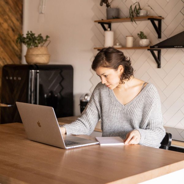 Chica trabajando en su casa con una notebook Mac
